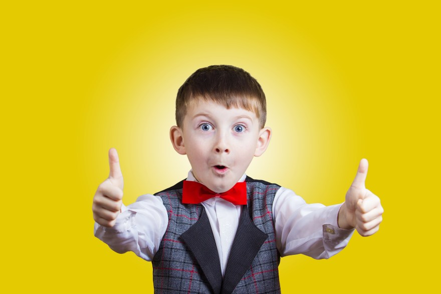 Excited Surprised little boy with thumb up gesture