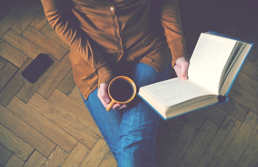 girl reading book and drinking fresh coffee