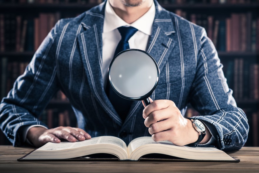 虫眼鏡を持った男性,たくさんの本