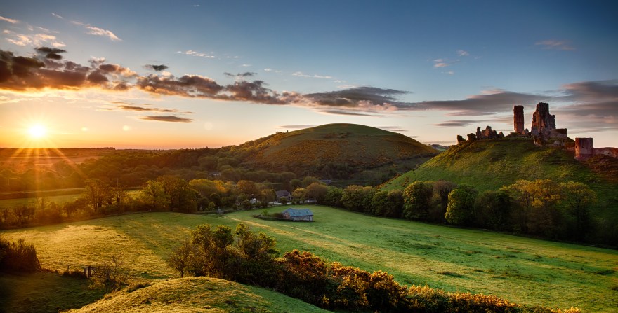 Beautiful sunrise panoramic over Corfe Castle in Dorset England