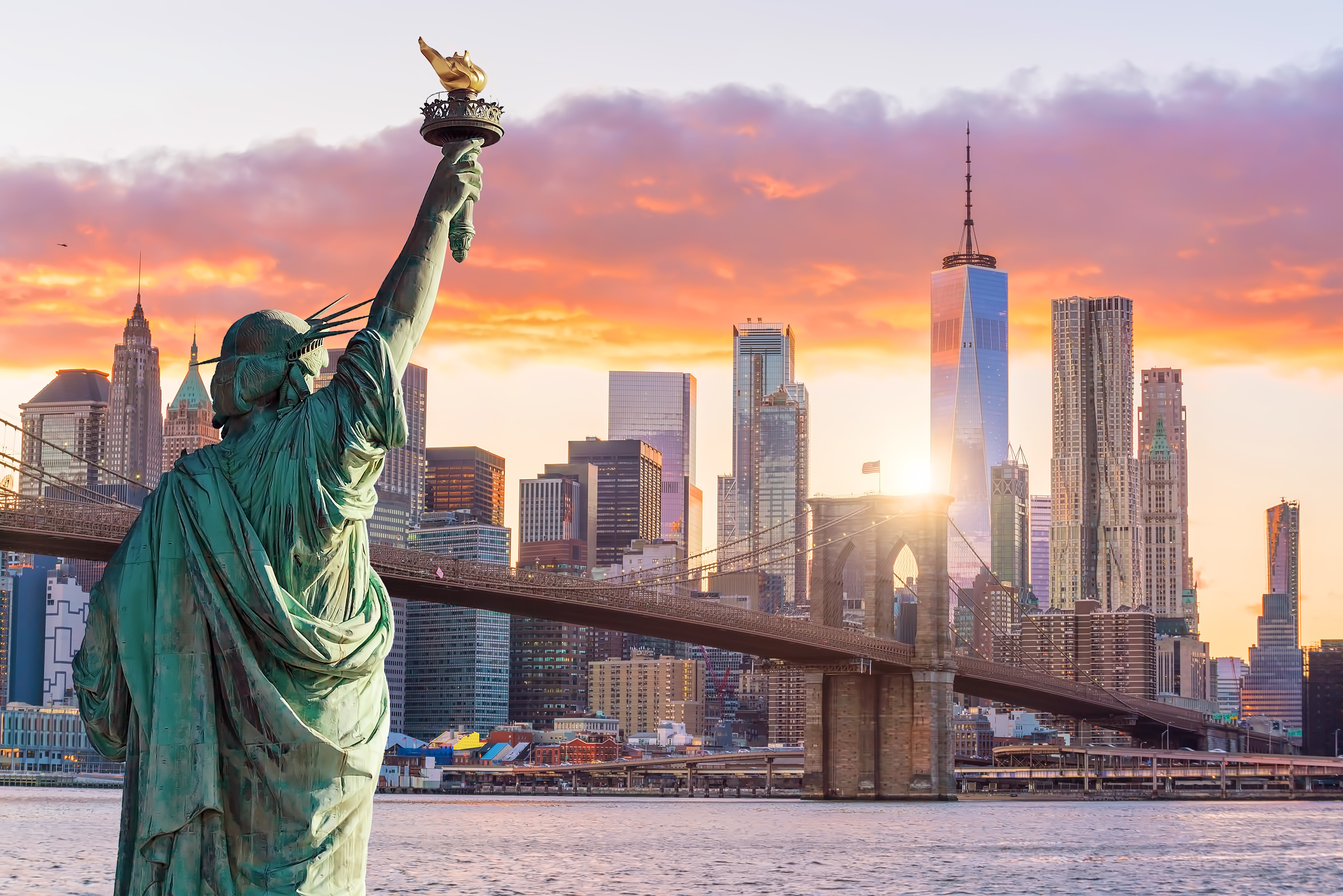 Statue Liberty and  New York city skyline at sunset