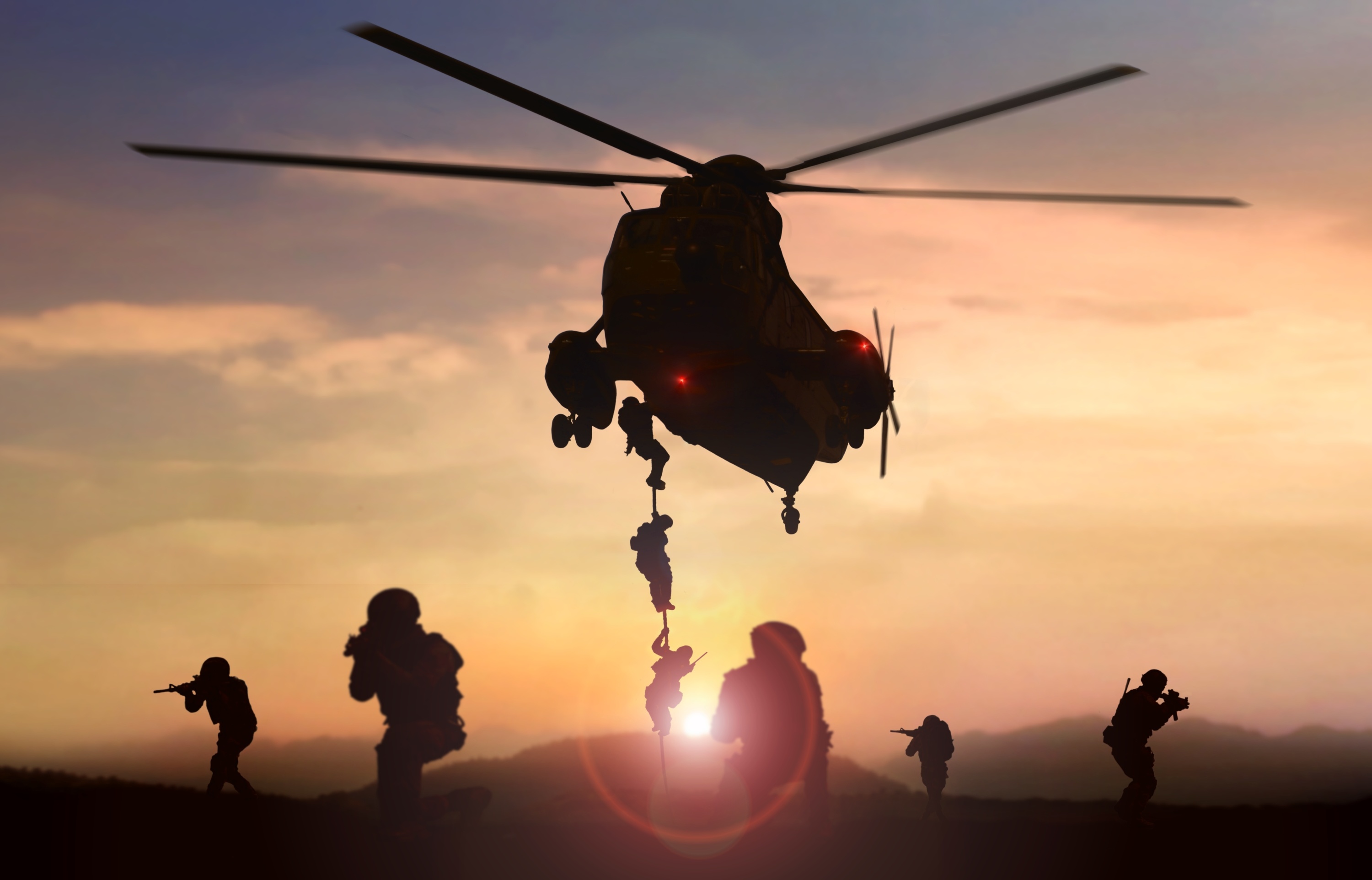 Special force assault team helicopter drops during sunset